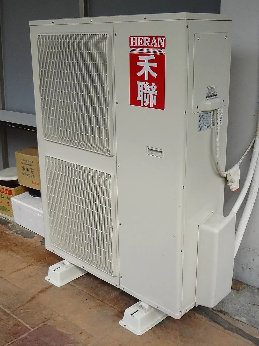 禾聯碩分離式冷氣室外機的正面，出風面朝外，機身緊鄰牆面。