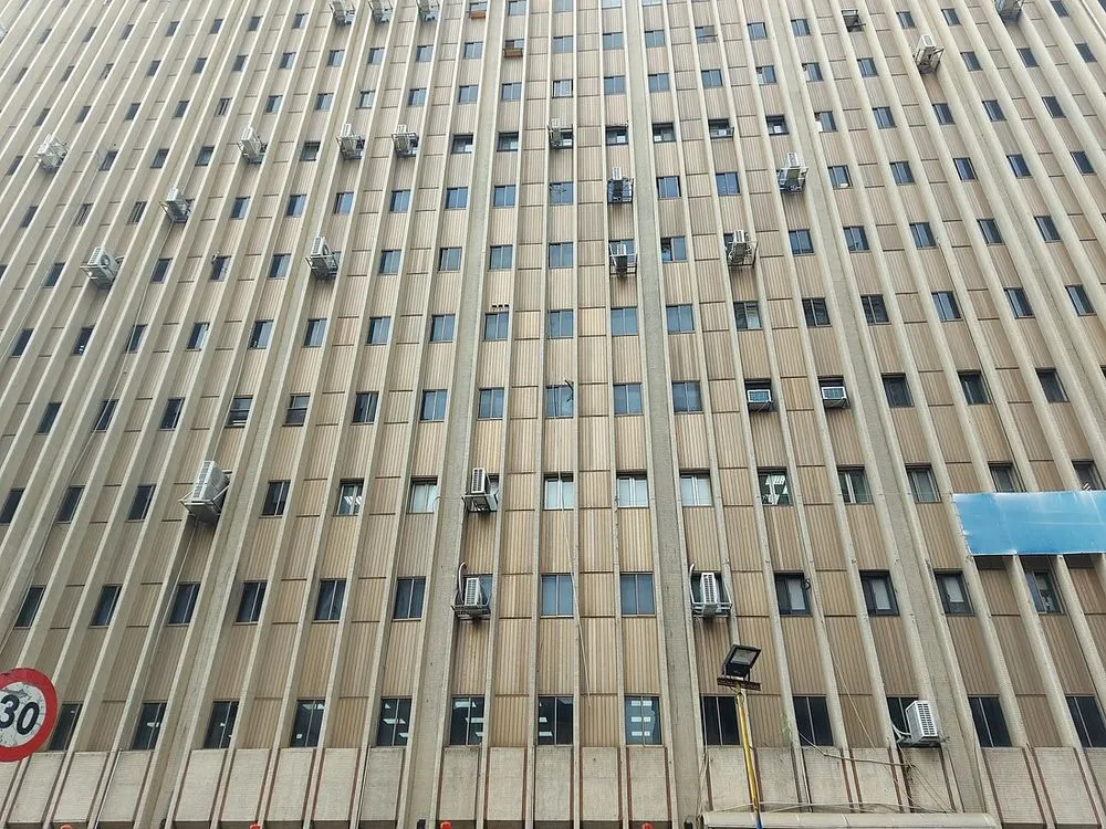一棟辦公大樓的外牆，設有百葉開口，內部裝設多台分離式冷氣室外機。