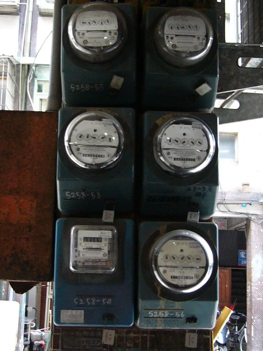 牆上並排的六具台灣電力公司電表，各自標有表號。